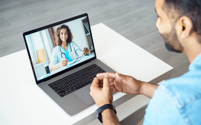 two healthcare professionals on a video call via computer